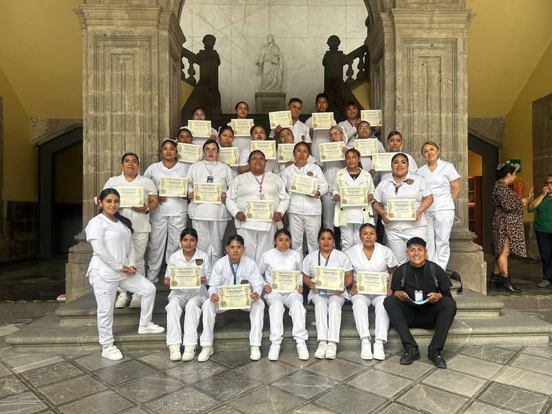 Grupo de alumnos del centro de capacitación con uniforme blanco